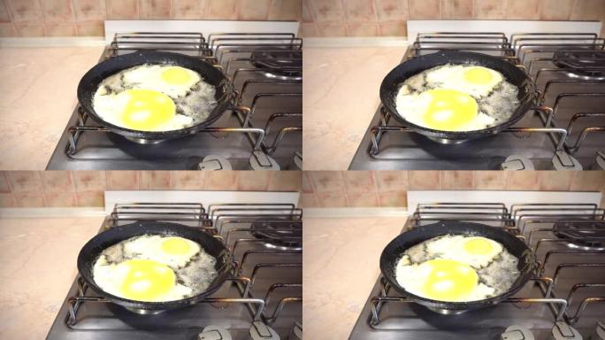 鸡蛋在平底锅和黄油中油炸，在家庭厨房中滚刀