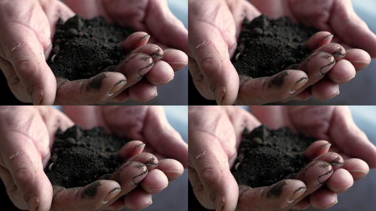 一个农民手里拿着地球的特写镜头。清洁生态土地为植物栽培主题。工作双手握住土壤。对地球的爱。选择性聚焦