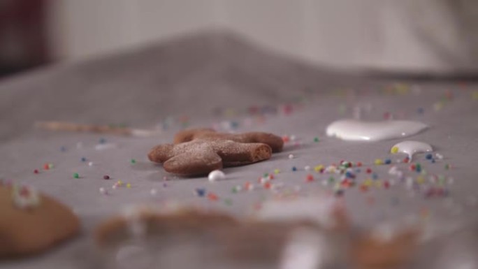 姜饼人饼干躺在糖霜和五颜六色的洒旁边