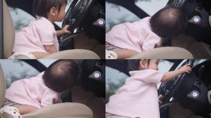 亚洲女婴玩汽车方向盘，孩子想象力，假装开车，坐在驾驶员前排座位上，天真的孩子好奇心和学习，快乐快乐的