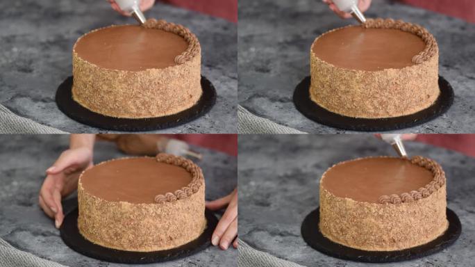 厨房里用巧克力奶油装饰蛋糕的女人拿着糕点袋