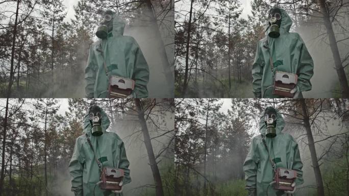 身穿危险品套装和防毒面具的低角度无法辨认的家伙站在切尔诺贝利附近放射性森林中间的烟雾中四处张望