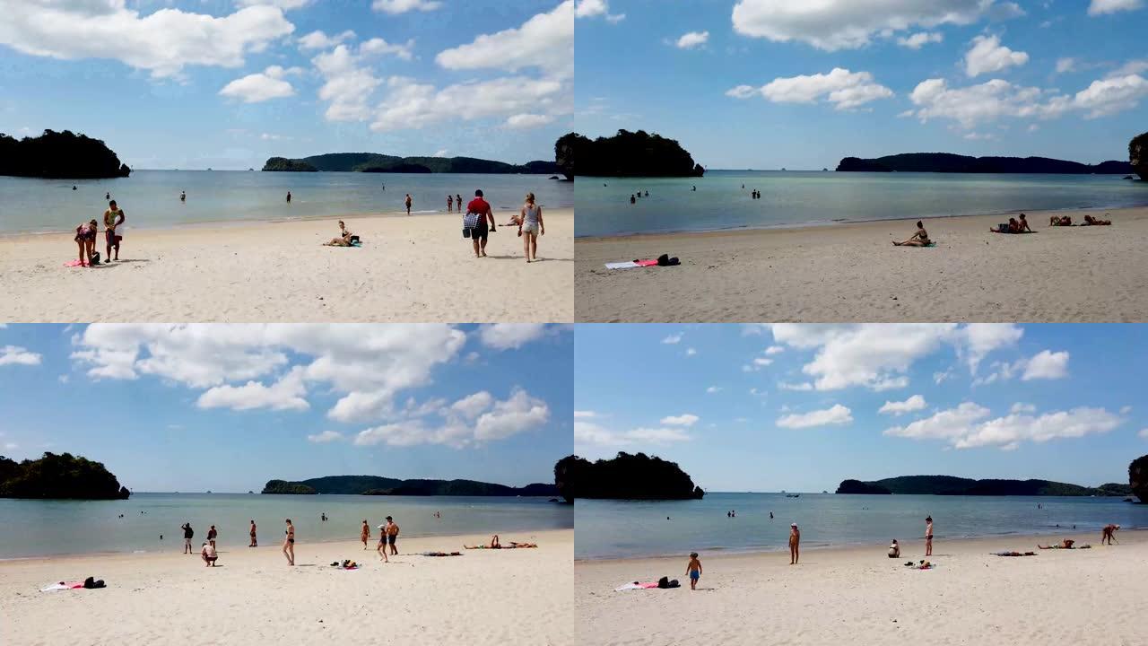 在泰国甲米美丽的海滩上，人们的延时镜头显示，如果天空中有云的水，人们会晒日光浴并进出。