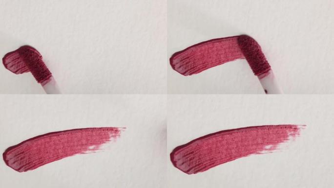 粉色化妆品唇彩涂片例子涂在白色背景上，涂刷特写