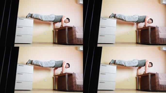 肌肉发达的运动员在家靠在床上做俯卧撑运动。