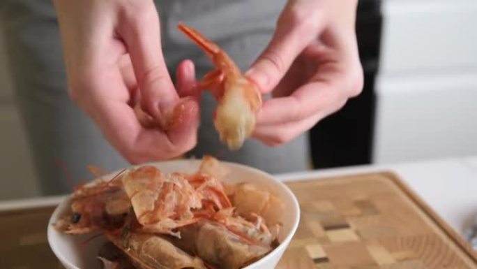 手剥虾壳的过程。女人清洗虾做饭
