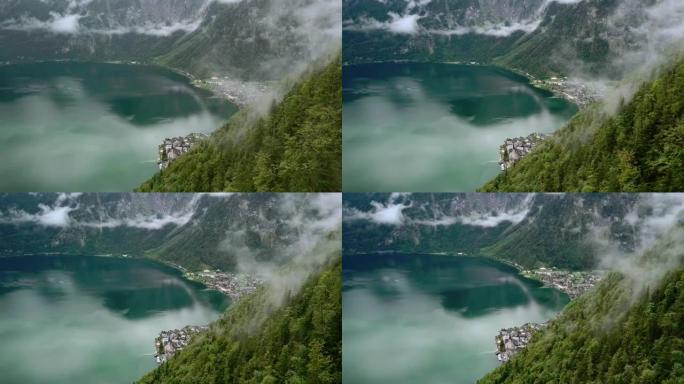 无人机在哈尔施塔特湖的空中全景，被云层群山环绕。奥地利自然。4k飞过云