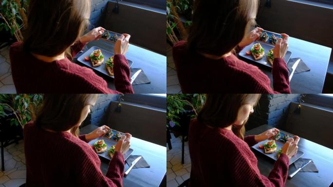 女性在餐厅用智能手机拍摄开胃食物