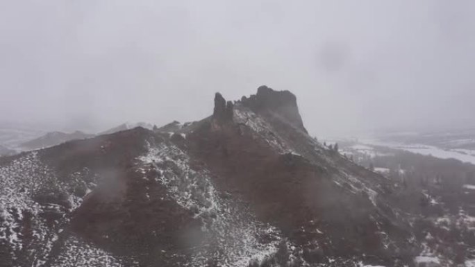 在暴风雪中飞过岩层的高峰