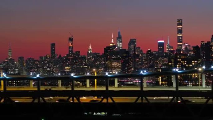 曼哈顿中城在夜晚照亮了天际线。RFK桥上有交通的景色。带有平移摄像机运动的无人机镜头。