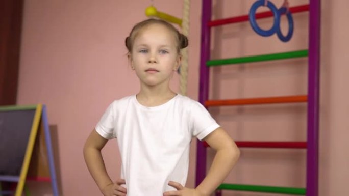 一个穿着白色t恤的小女孩进行锻炼，将头向右和向左转动。
