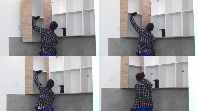 木匠将新组装的厨房架子放在预定的位置。