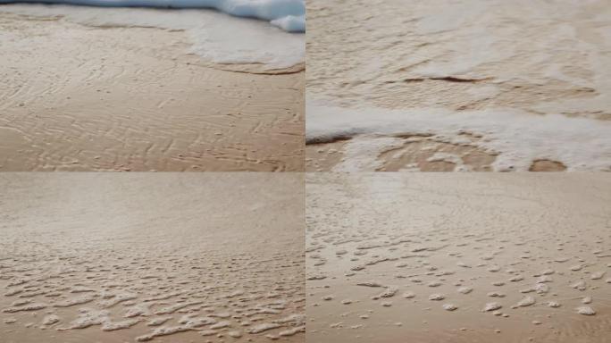 在温暖的晴天，白色泡沫在日落时在带有金色沙滩的海滩上冲浪