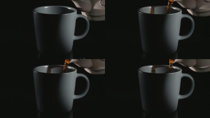 将茶倒入陶瓷杯中。黑色背景下的特写镜头。