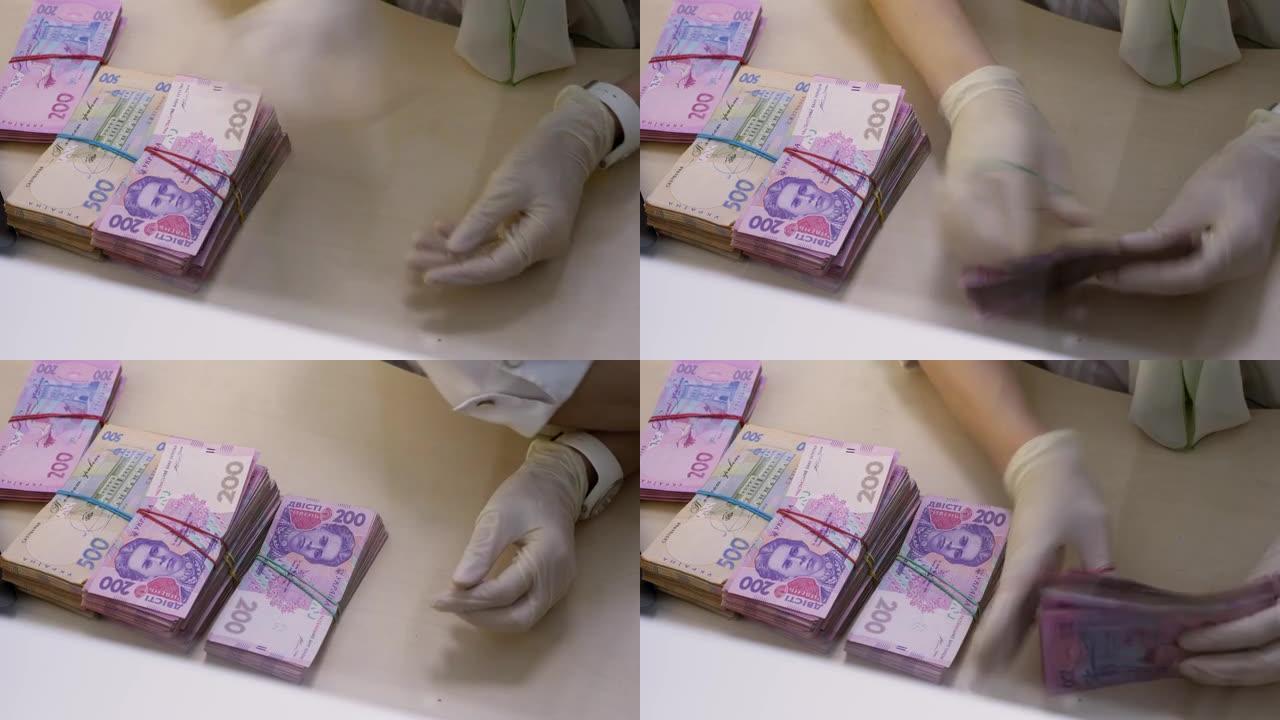 手手套叙述格里夫尼亚。货币兑换。乌克兰银行。现金部。算上乌克兰格里夫尼亚。UA货币。一捆格里夫尼亚。