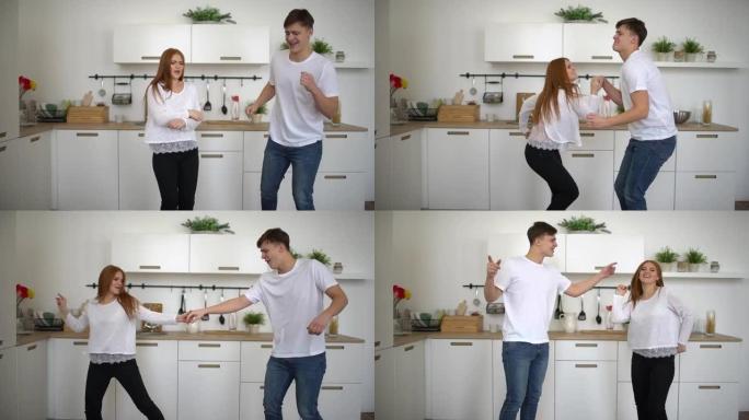 一对新结婚的年轻夫妇早上在家穿着睡衣在厨房里快乐跳舞听音乐。慢动作