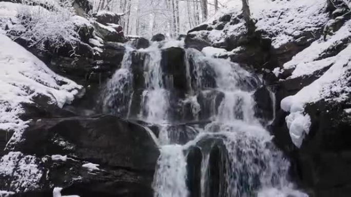 山区的冬季瀑布。水冲破冰雪