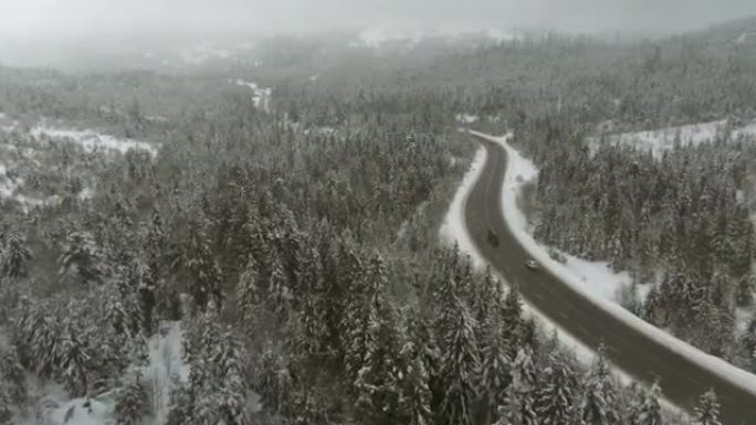 在寒冷的雾蒙蒙的冬日，雪山中的山区运输道路-鸟瞰图