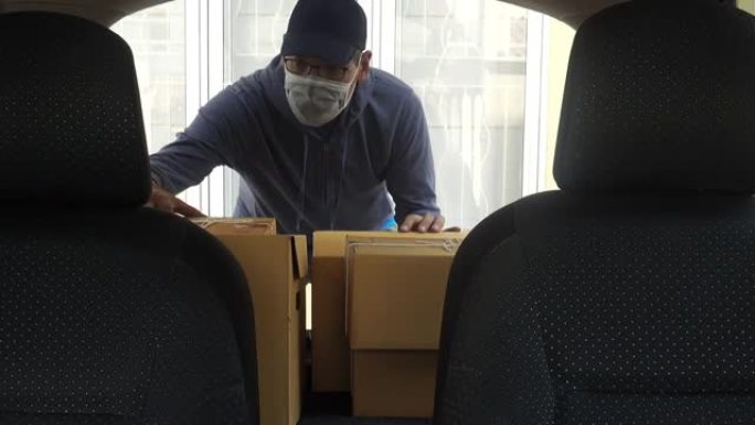 成熟的小企业主戴着口罩送货包裹给顾客开车