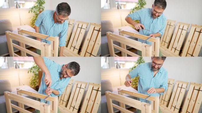 男子在家中使用螺丝刀组装新桌子