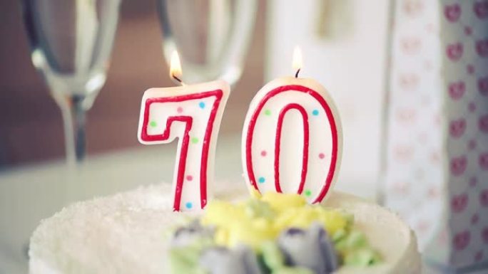 生日蜡烛作为70号70在桌子上的甜蛋糕上，70岁生日，色调图片