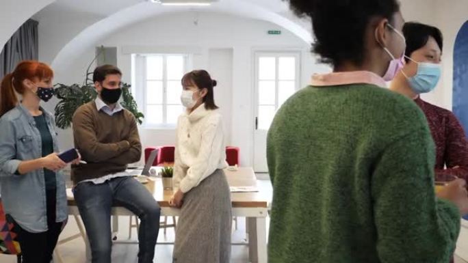 在办公室工作时戴口罩的多元化员工