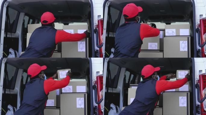 非洲送货员戴着口罩在卡车上装载箱子，以避免电晕病毒传播 -- 在电晕病毒爆发期间，工作人员快速送货
