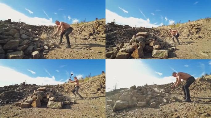 岩石背景上有硬锤的运动员。户外运动男子，不穿衬衫，用金属锤打碎石头。慢动作。