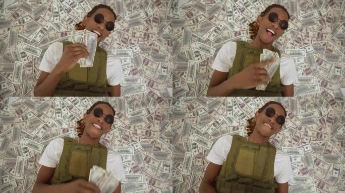 黑人躺在一堆美元钞票上。戴着眼镜的黑人男性躺在钱上，带着快乐的表情扔钞票。钱雨