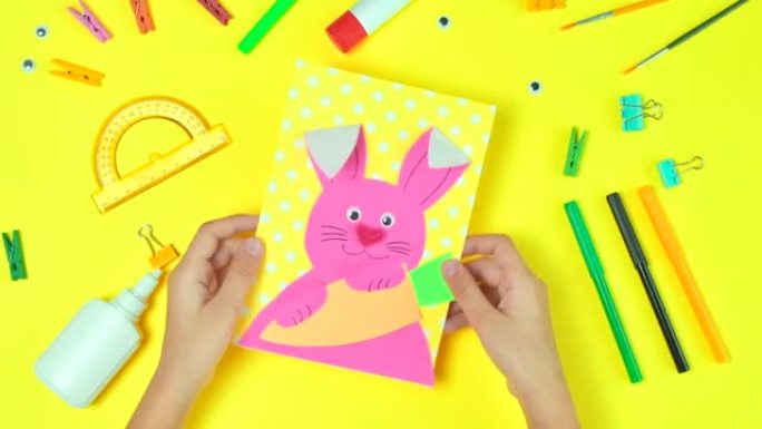 DIY和孩子们的创造力。分步说明: 用兔子和胡萝卜创建复活节卡。儿童手工复活节工艺品。顶视图。