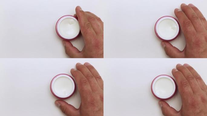 一个人的手握着并旋转着一罐奶油。