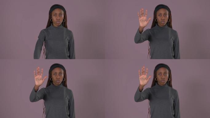 非洲妇女举起手的肖像，手掌上有停止铭文。停止对妇女的暴力。女性权利。滥用问题