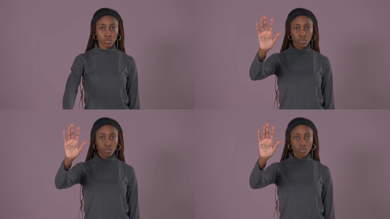 非洲妇女举起手的肖像，手掌上有停止铭文。停止对妇女的暴力。女性权利。滥用问题