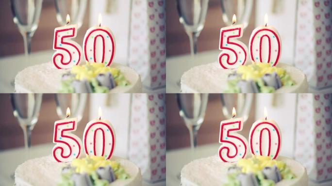 生日蜡烛作为50号50在桌上的甜蛋糕上，50岁生日，调子视频