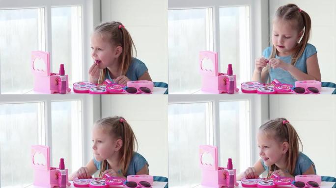 美丽的小女孩用儿童口红涂嘴唇，照镜子。孩子在玩具美容院在家玩耍。
