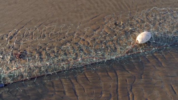 空的工业渔网躺在沙滩上。