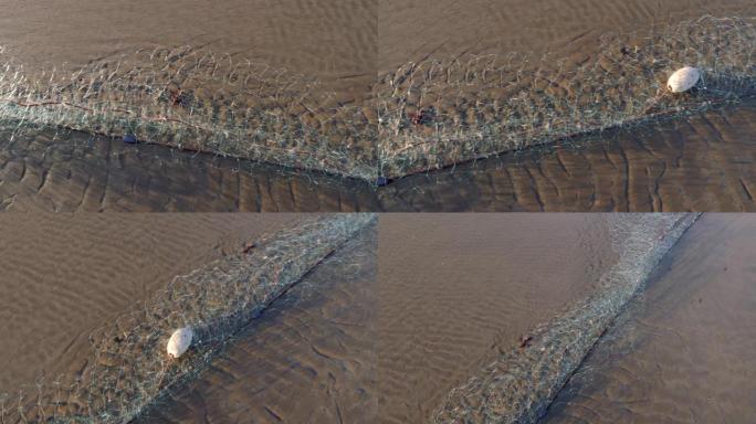 空的工业渔网躺在沙滩上。