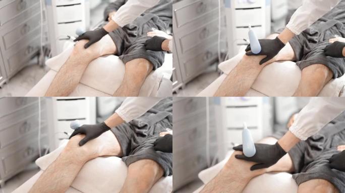 医生对男性膝盖进行磁疗