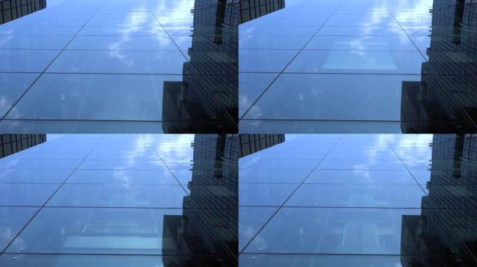 现代商业建筑中的移动电梯。电梯上升。向上看。窗户反射着蓝天白云。