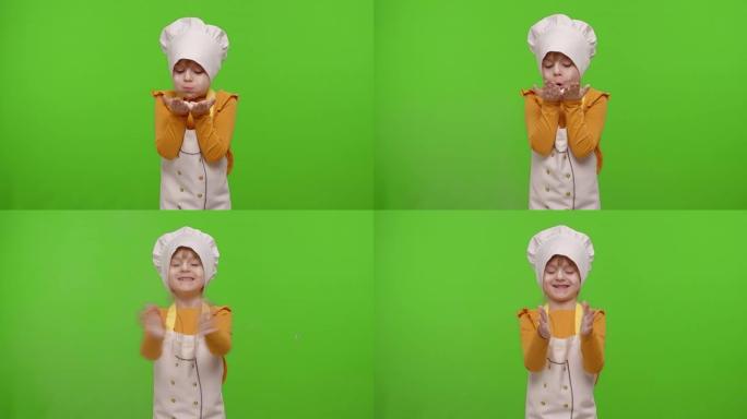 打扮成专业厨师的女童小孩在色度键上将面粉从手中吹入相机