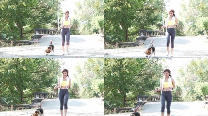 年轻的亚洲妇女在夏天和她的狗在公园里锻炼。