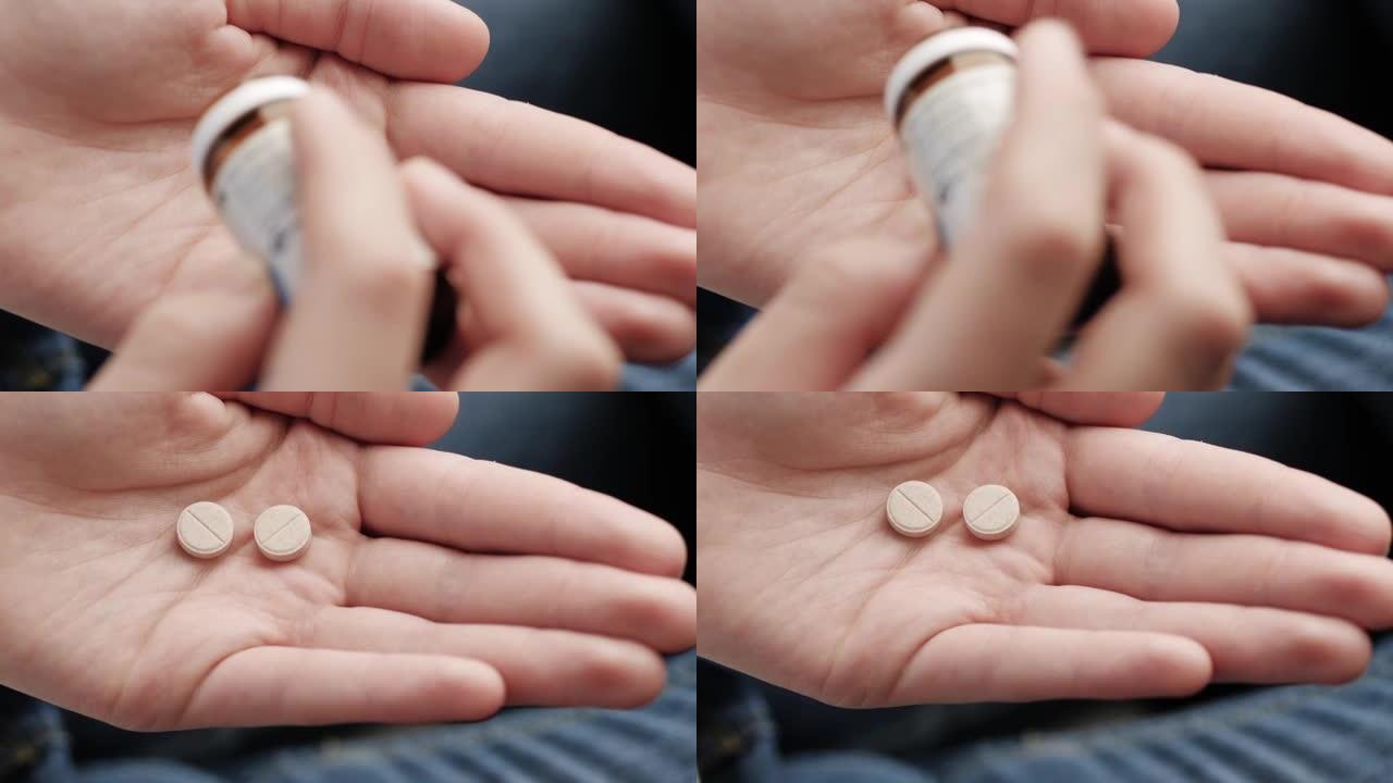 两个浅棕色的大圆形药丸从药瓶中落入手掌。特写，顶视图