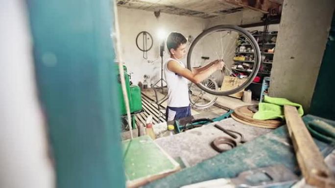 一个十几岁的男孩在修理自行车轮子的辐条