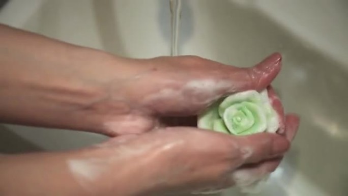 女性手中的花朵形状的手工皂