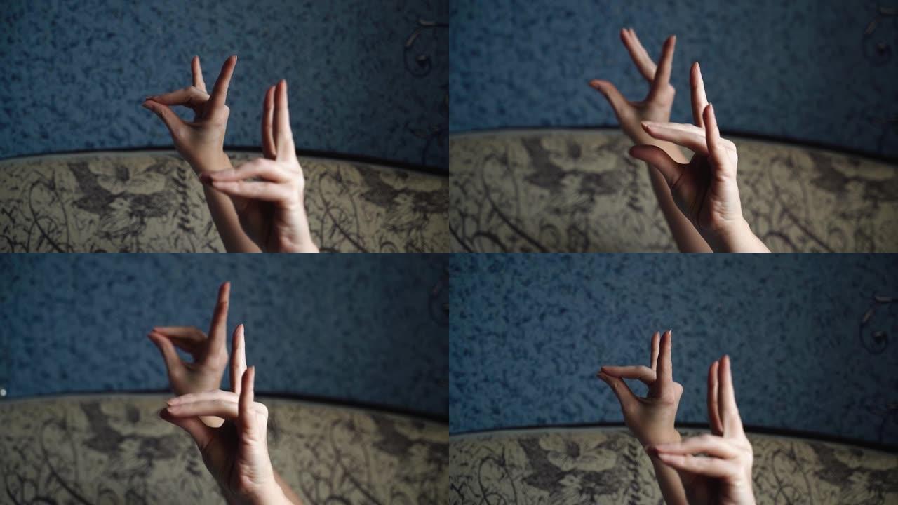一个女人用手指做热身。她躺在沙发上做手部练习