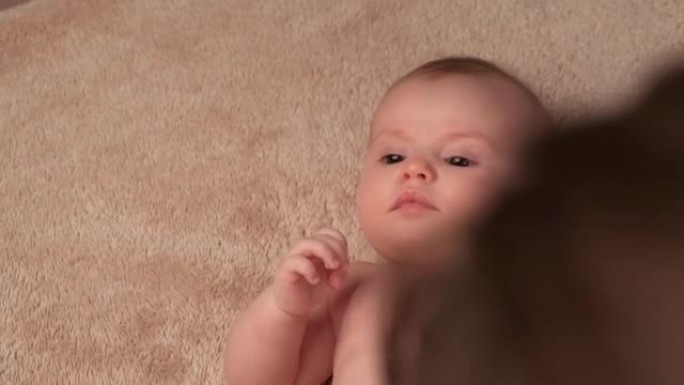 一名高加索父母在新生儿身体按摩上涂抹特殊乳霜的上视视频