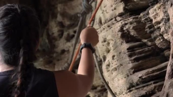 4k亚洲女子登山者准备用安全绳和安全带爬上落基山