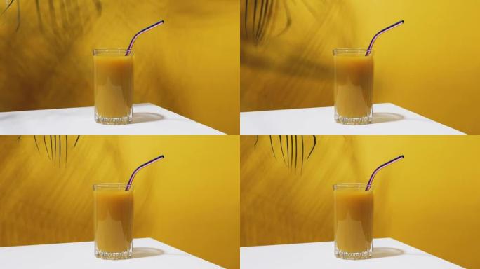 一杯新鲜的芒果汁和棕榈枝随风吹来。