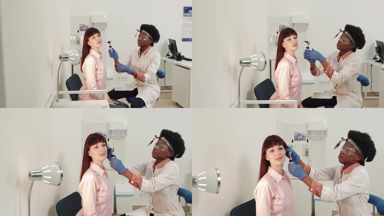 耳鼻喉科医生。非裔美国女医生。耳鼻喉科医生检查一个抱怨疼痛的女孩的耳朵。疼痛缓解和治疗理念。耳道或鼓