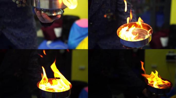 魔术师放火烧金属盘中的易燃液体。